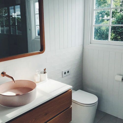 Salle d’eau avec vasque rose et meuble en bois